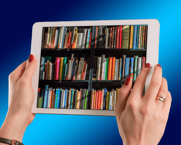 hands holding tablet with library shelf image