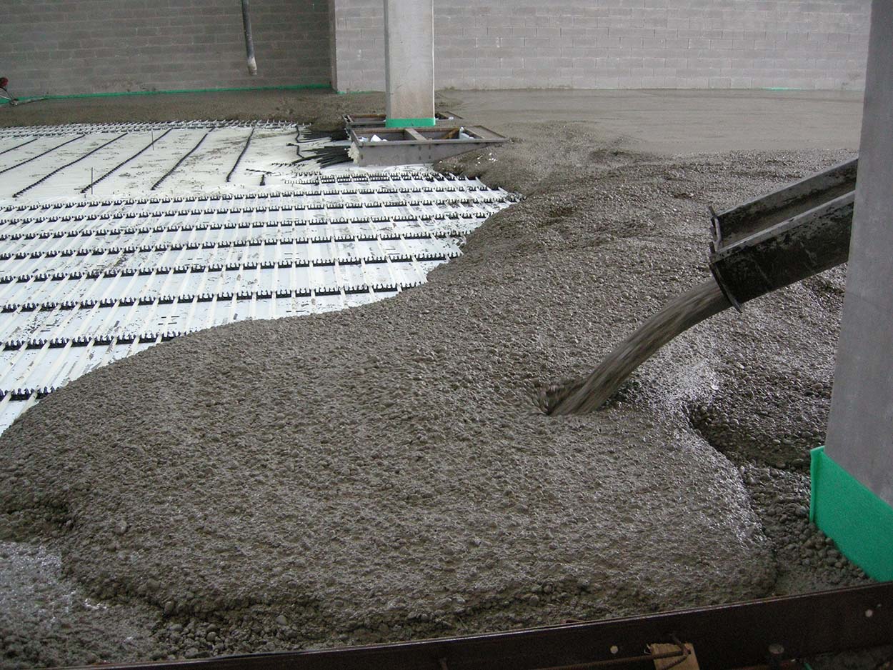 Placing concrete to create an industrial floor with an underfloor heating system.